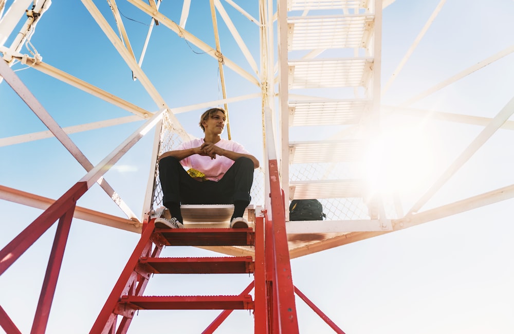 man sitting on red staircase