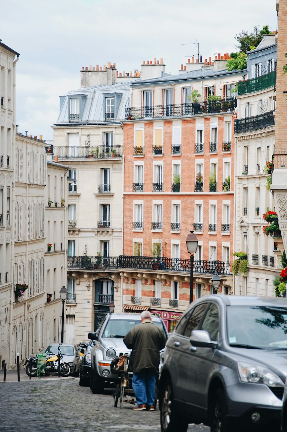 homme marchant à côté d’un véhicule gris \