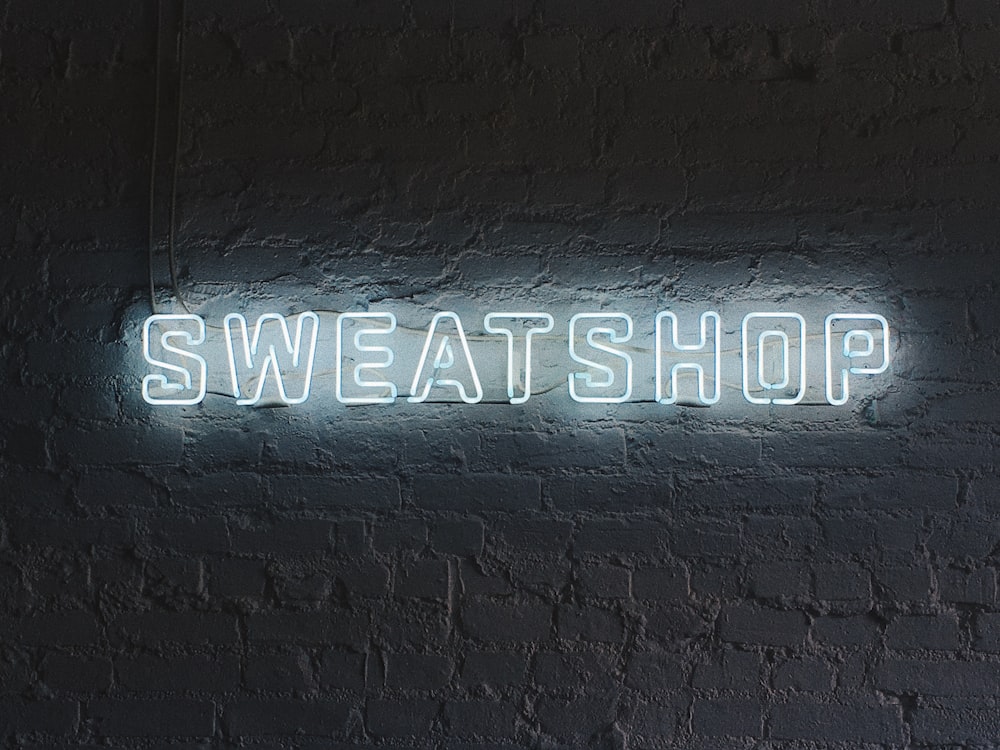 turned on white Sweatshop neon signage