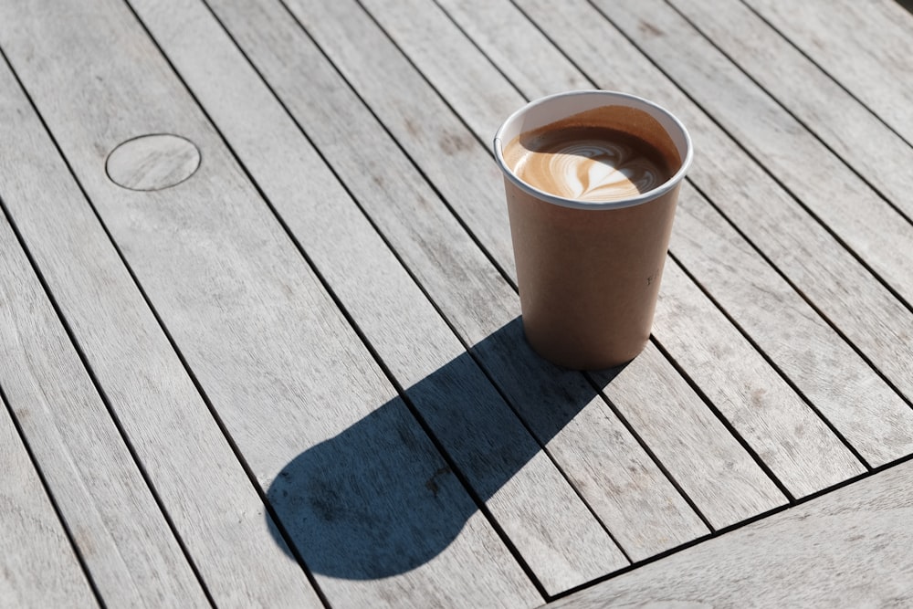 cappuccino on grey wooden planks at daytime