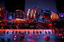 Soundcheck scene with colorful stage lights casting shadows on equipment.