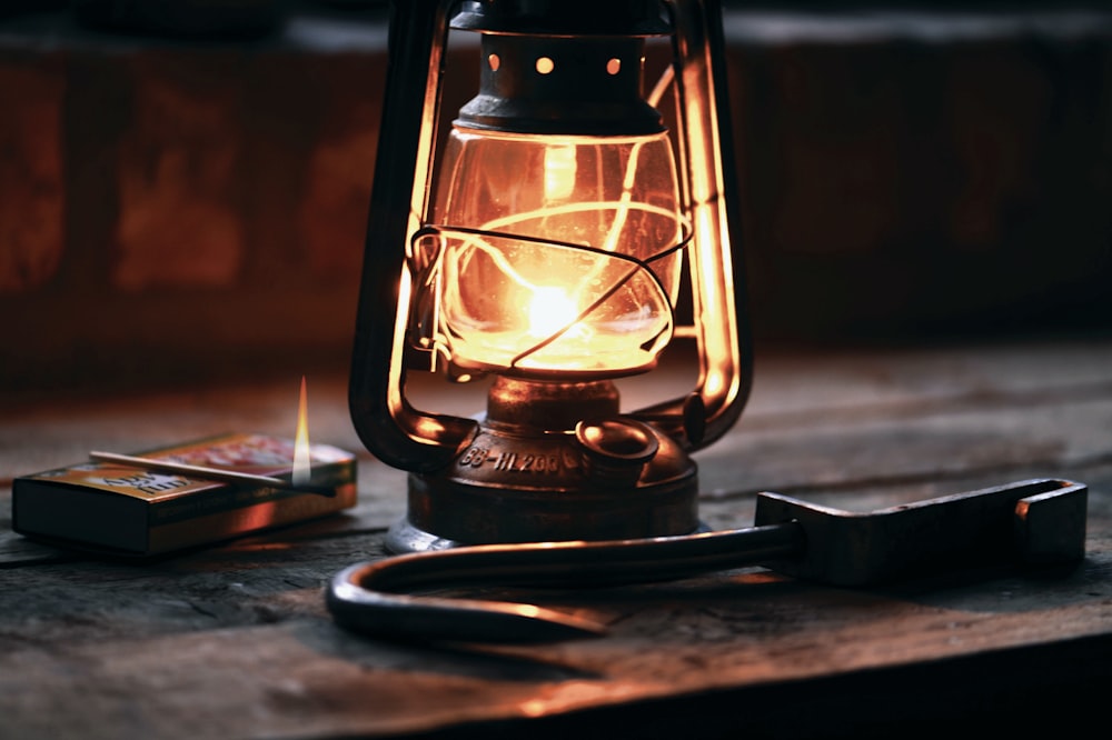 lantern beside black metal hook on brown furniture