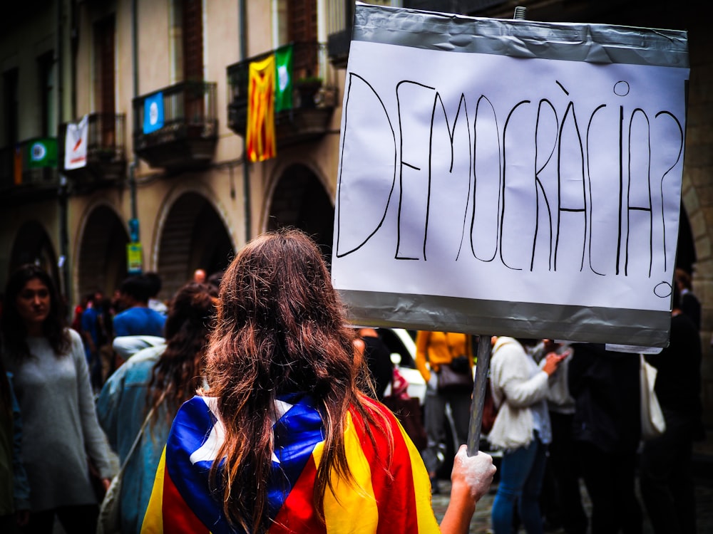 Mujer sosteniendo carteles de Democracia