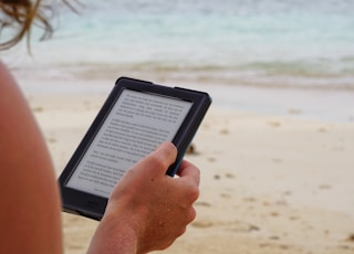 person holding black tablet computer during daytime