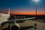 Close-up of jet fuel being pumped into an aircraft wing at dawn.
