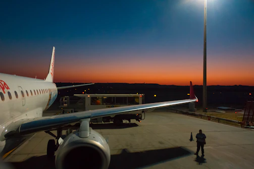 Airplane being refueled at a modern service station at sunset.