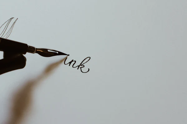 A hand writing a letter with a fountain pen