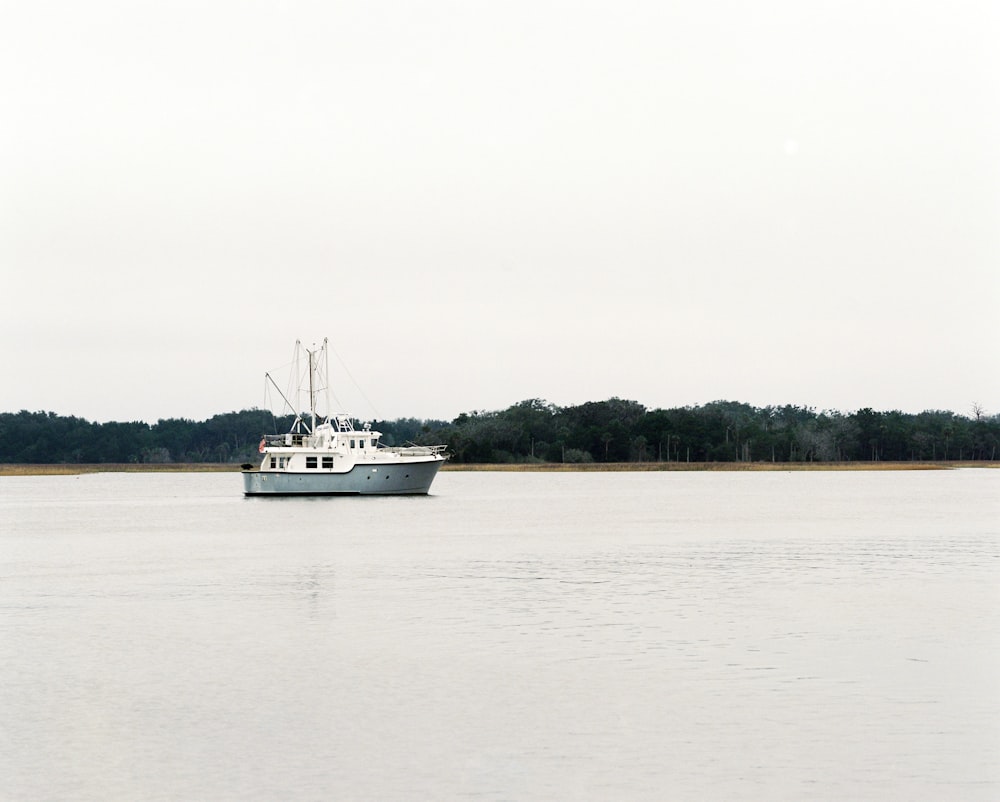 photo of white cargo ship in the middle of the sea