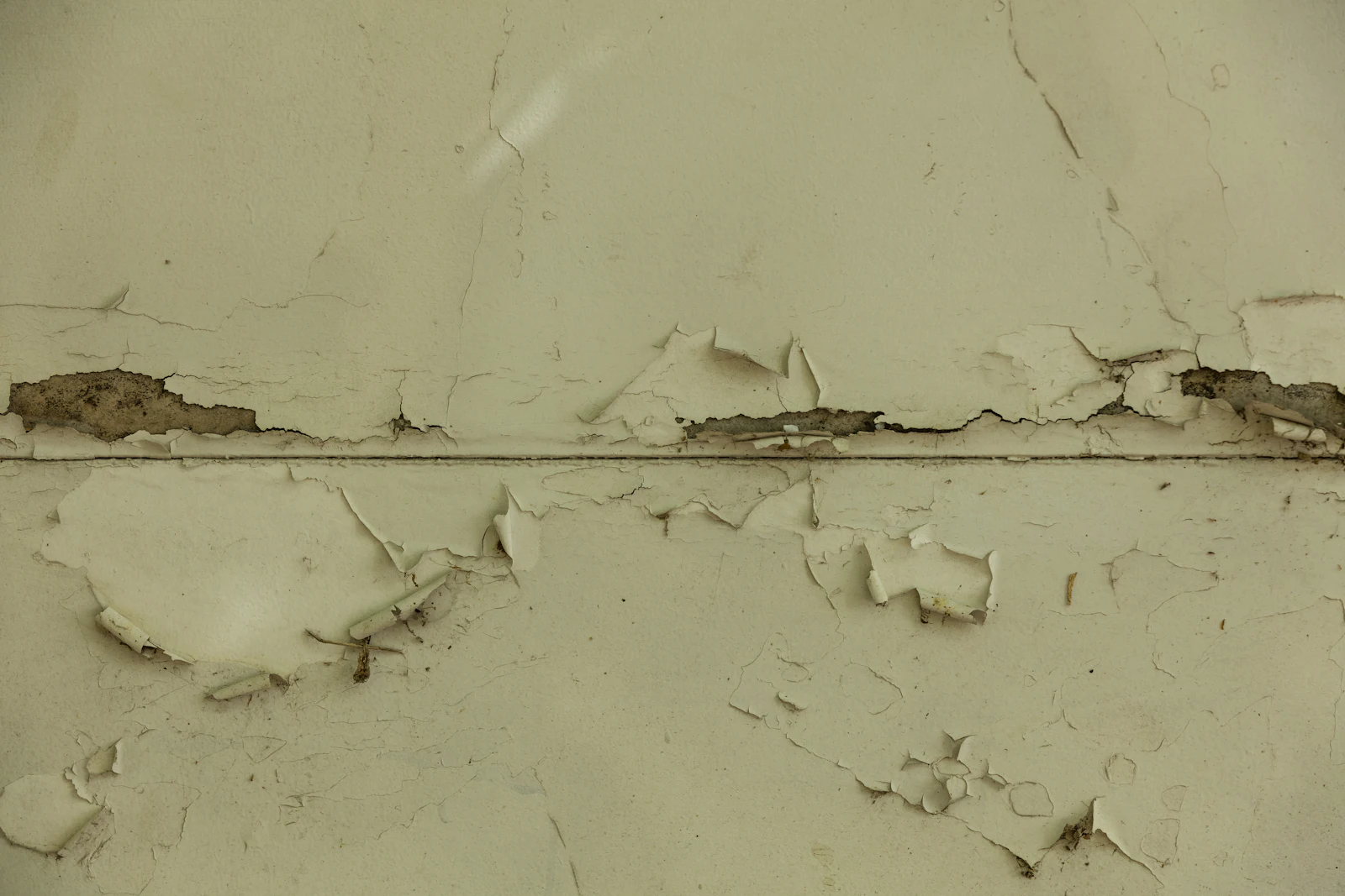 A wall with paint peeling from water damage