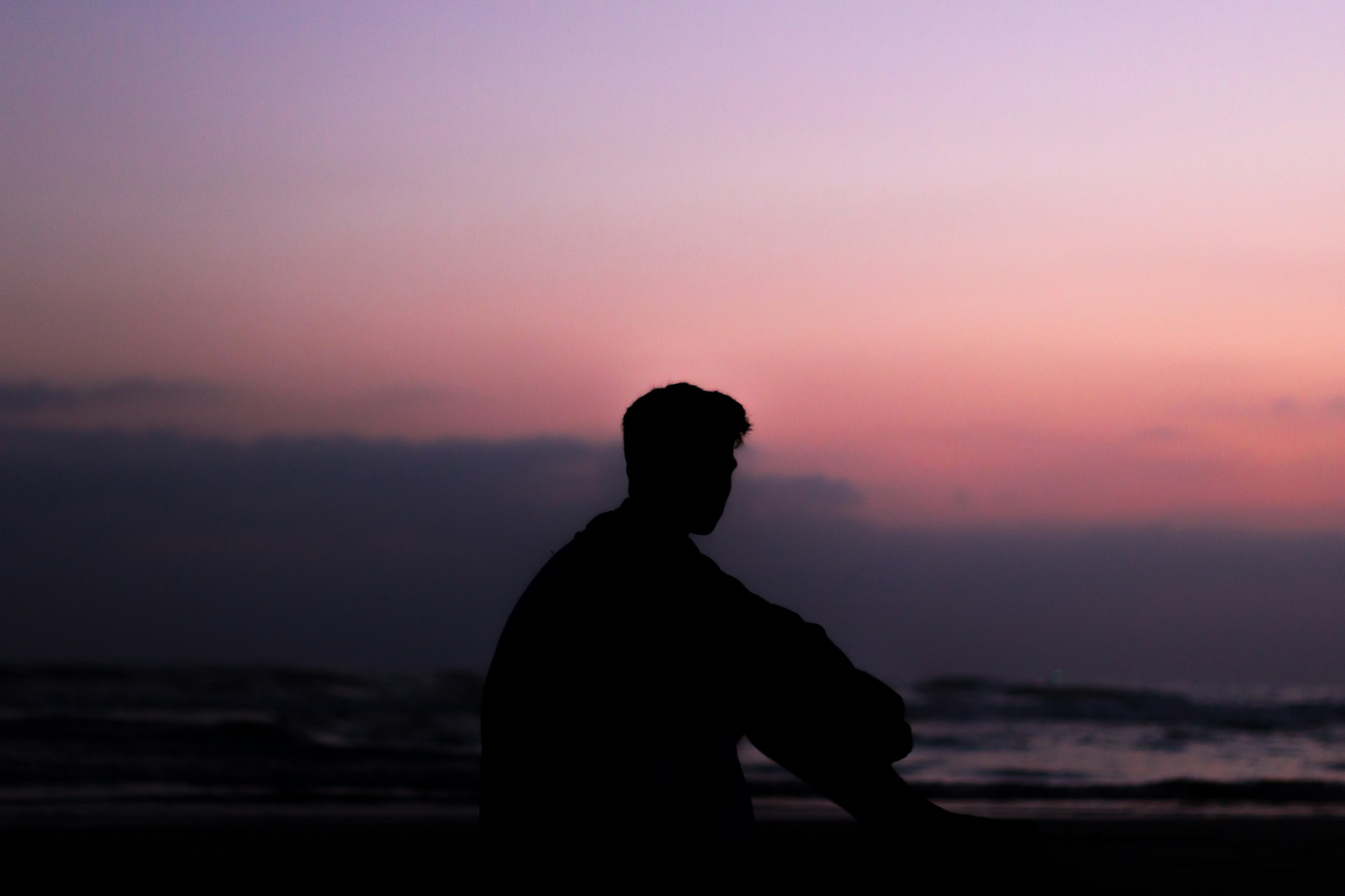 silhoutte of man sitting on ground