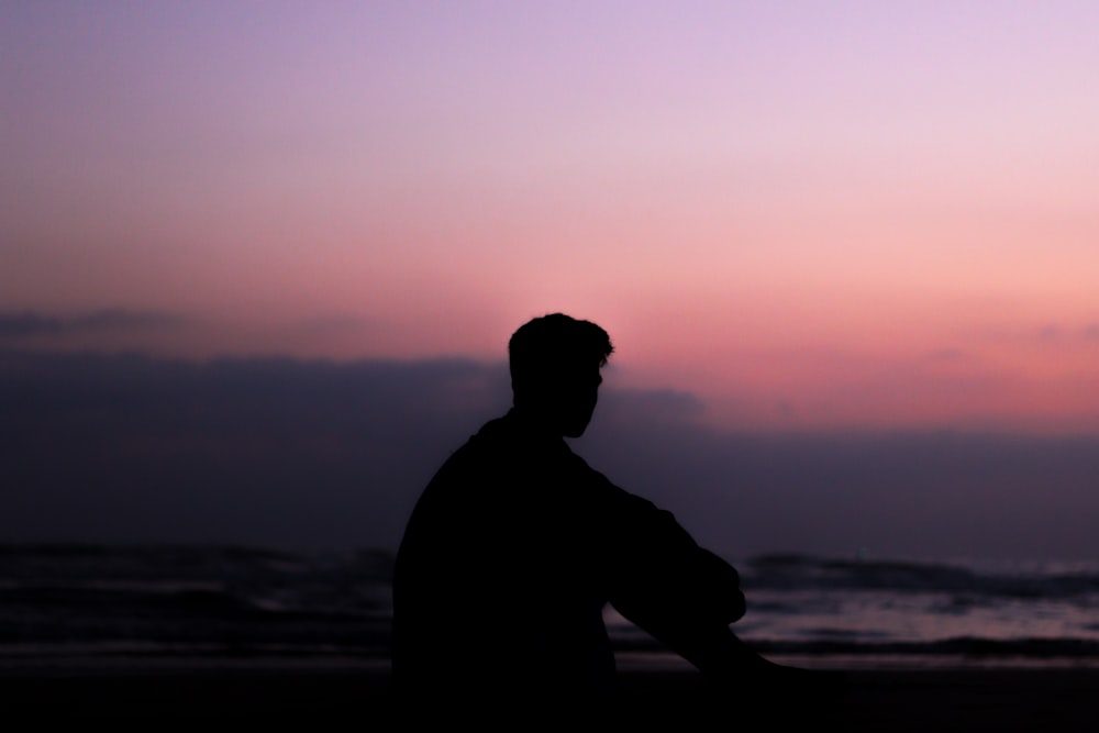 Silhoutte d’homme assis sur le sol