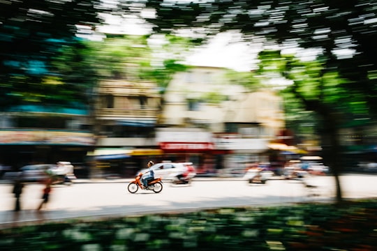 tilt shift photography of man riding motorcycle in Hanoi Vietnam
