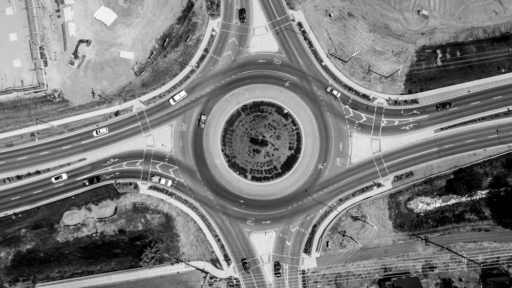 Graustufenfotografie der Straße mit vorbeifahrendem Fahrzeug