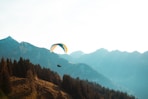 person paragliding near mountain at daytime