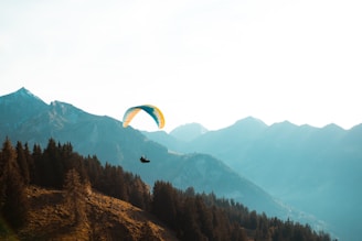 person paragliding near mountain at daytime