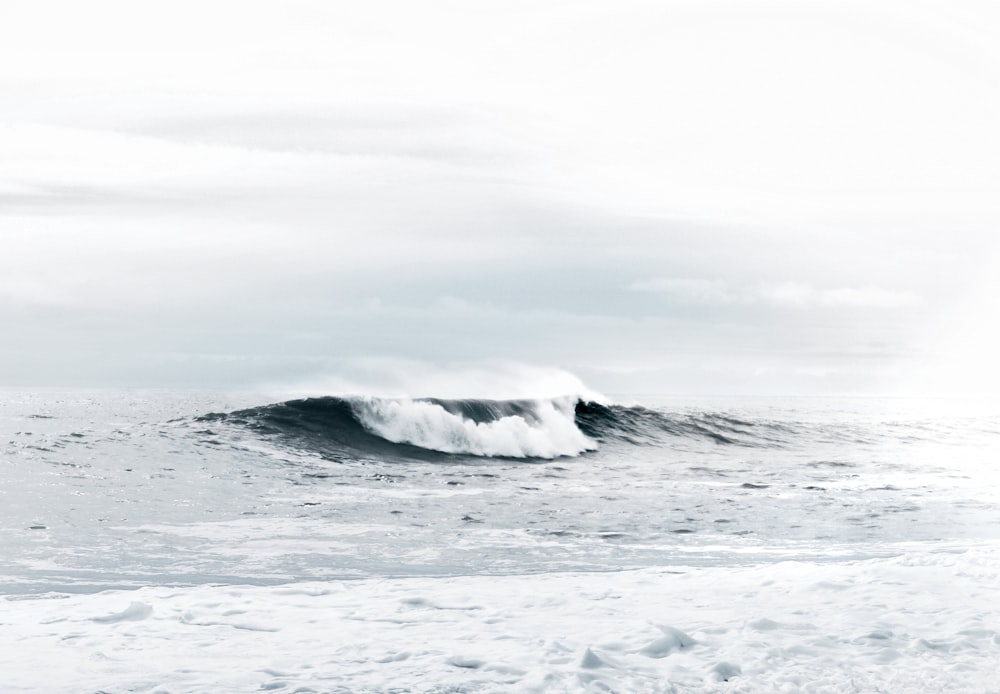 waves under cloudy sky during daytime