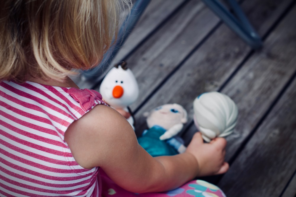 girl playing Disney Frozen character toy