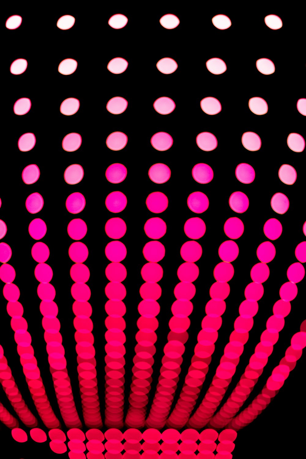 a black background with pink and white circles