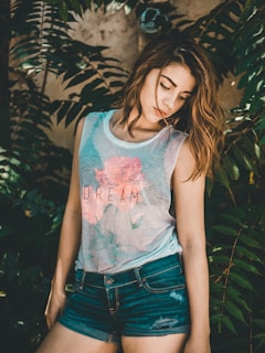 woman posing for photo beside green plants