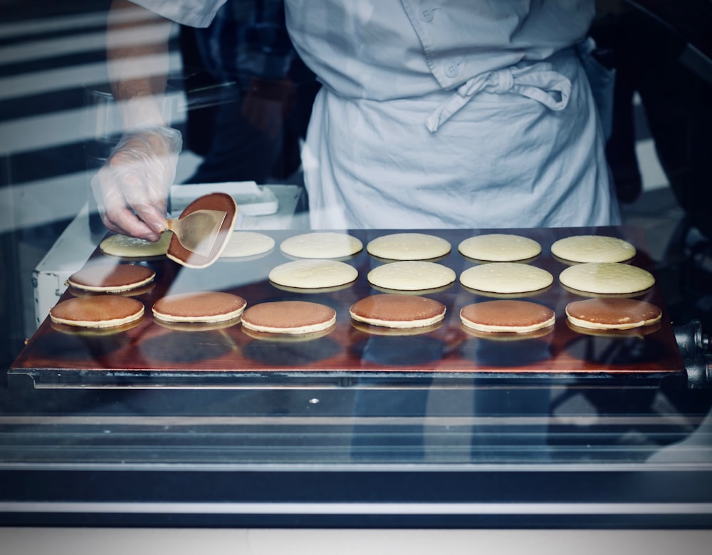 person in white apron baking flatbread