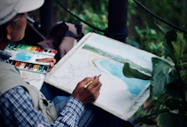 man holding brown and black pen painting seashore