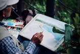 man holding brown and black pen painting seashore