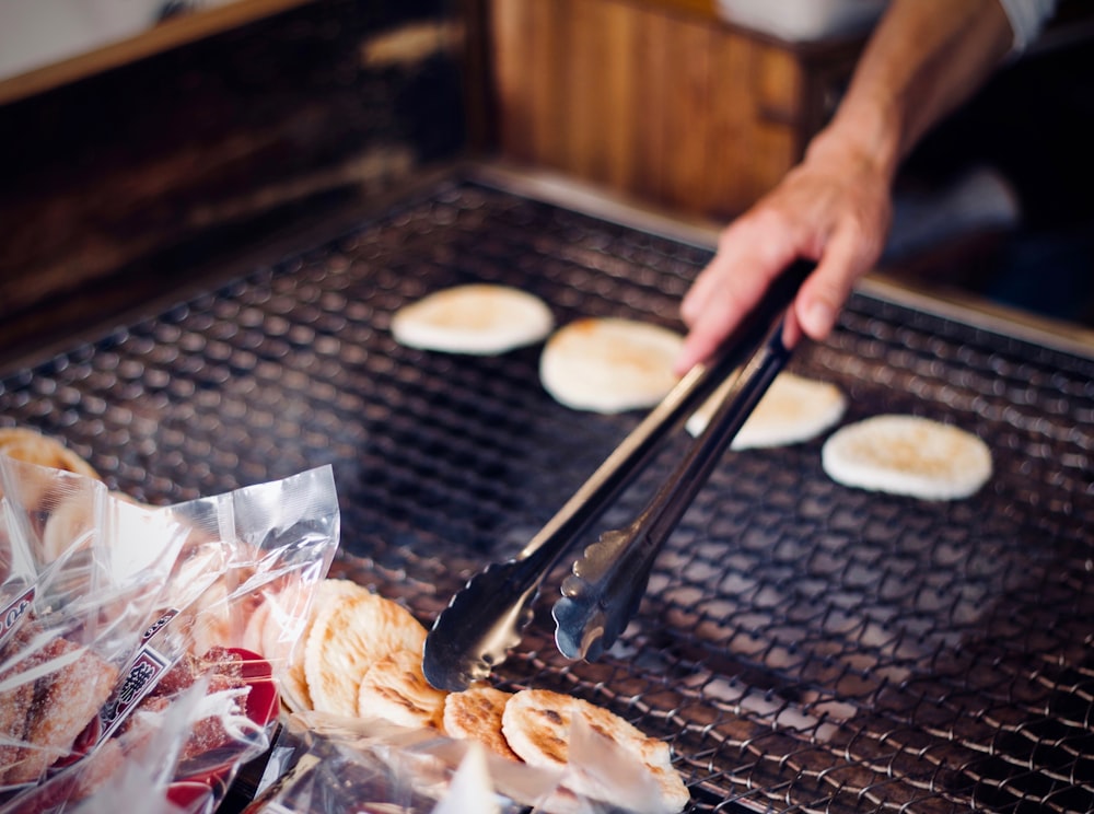 personne tenant une pince pendant la cuisson