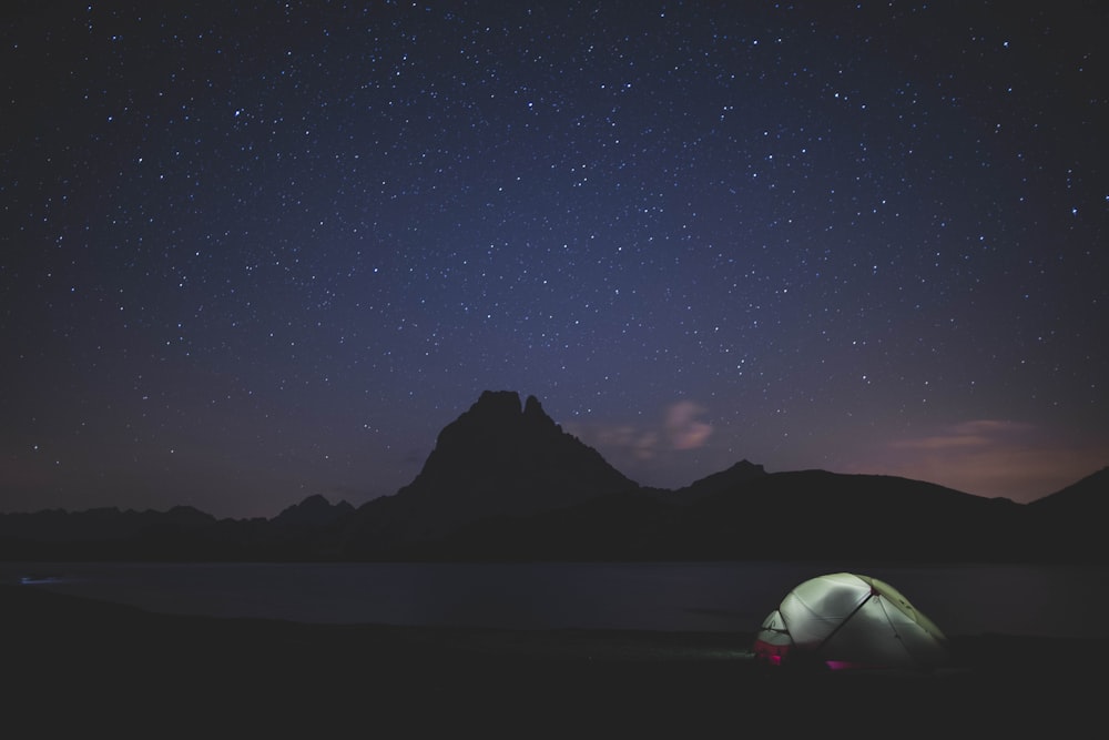 silhouette photography of mountain under cluster of stars