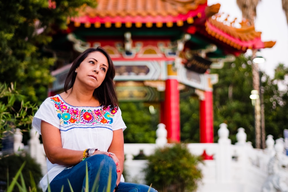 woman sitting near gazebo and green plants