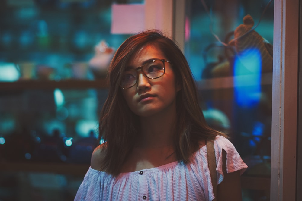 Femme debout devant un panneau de verre