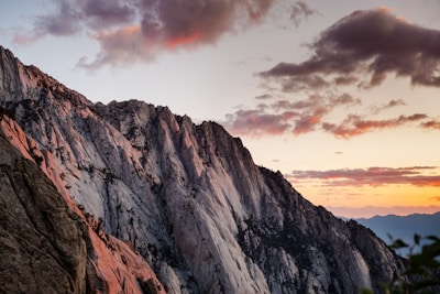 A dramatic mountain range filmed at sunset with soft cinematic color grading.