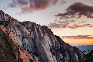 A dramatic mountain range filmed at sunset with soft cinematic color grading.