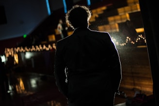 A candid shot of an actor rehearsing lines on a dimly lit theater stage.