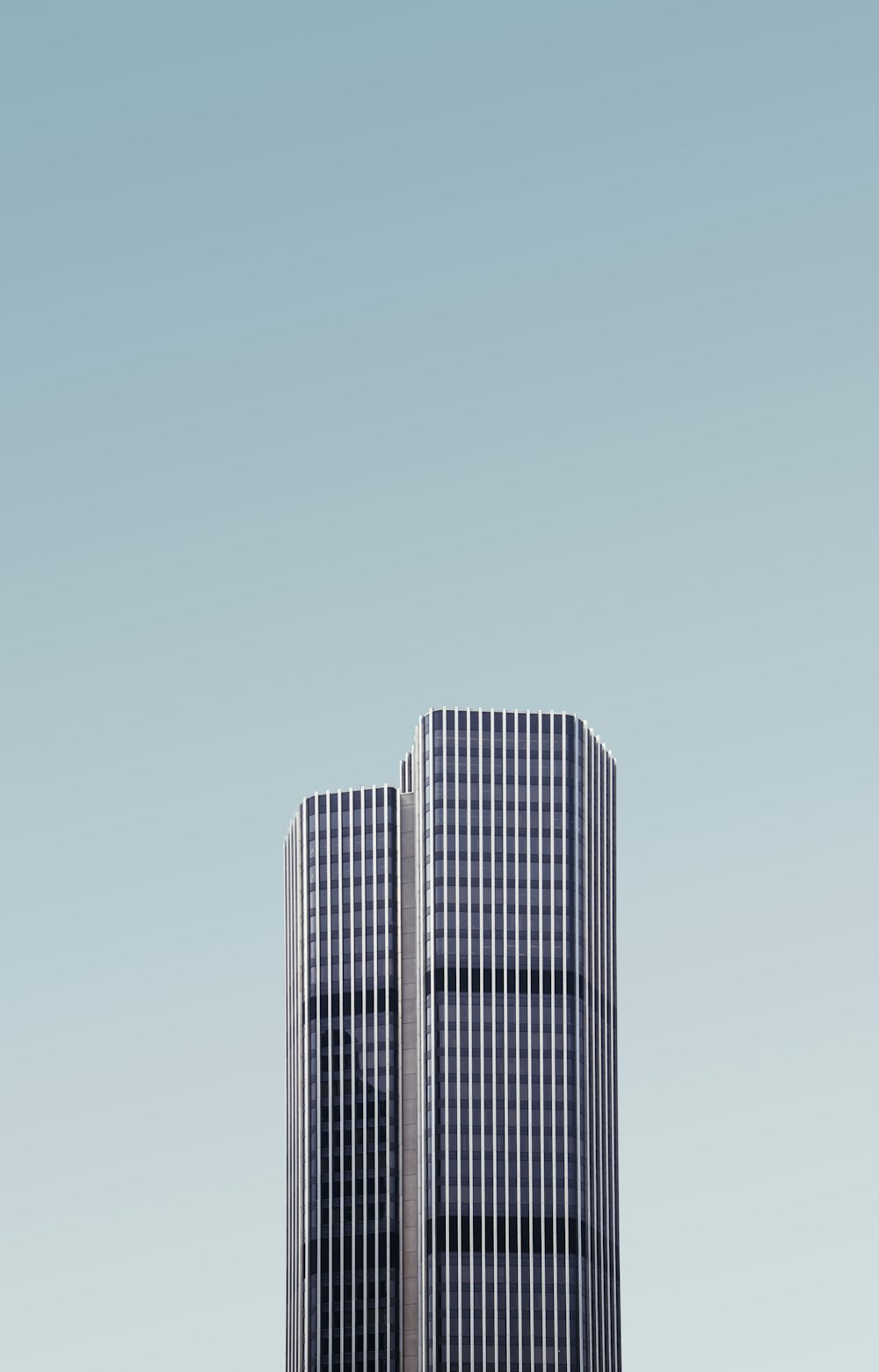 grey and white high-rise building under white cloudy sky