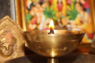 Artist carefully crafting a lamp inspired by world religions, surrounded by sketches and materials.