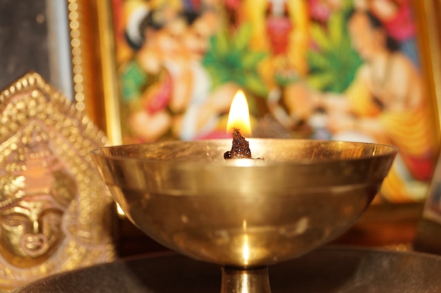 Artist carefully crafting a lamp inspired by world religions, surrounded by sketches and materials.