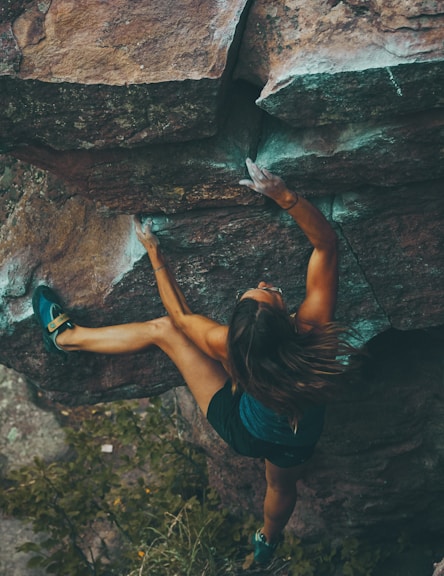 photo of woman climbing mountain