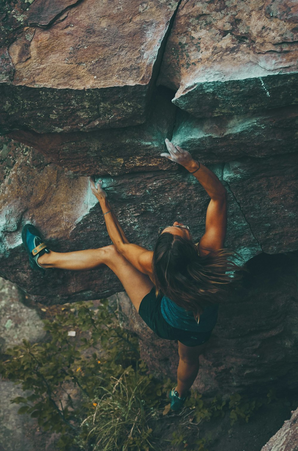 A woman climbing up the side of a rock photo – Deportes Image on Unsplash