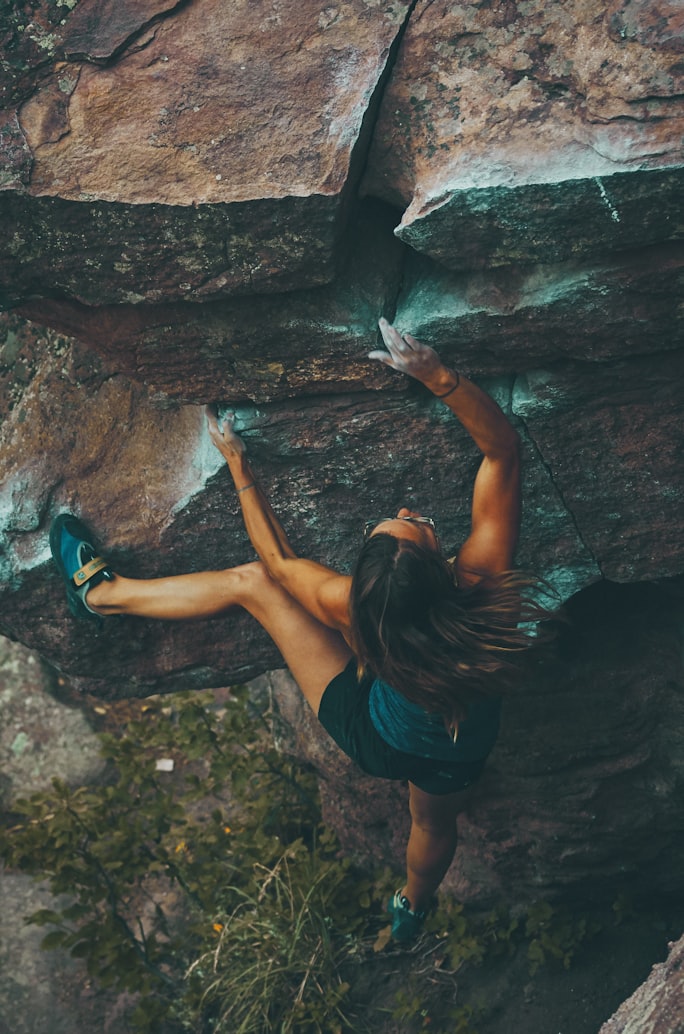 picture of a womam climbing a cliff face