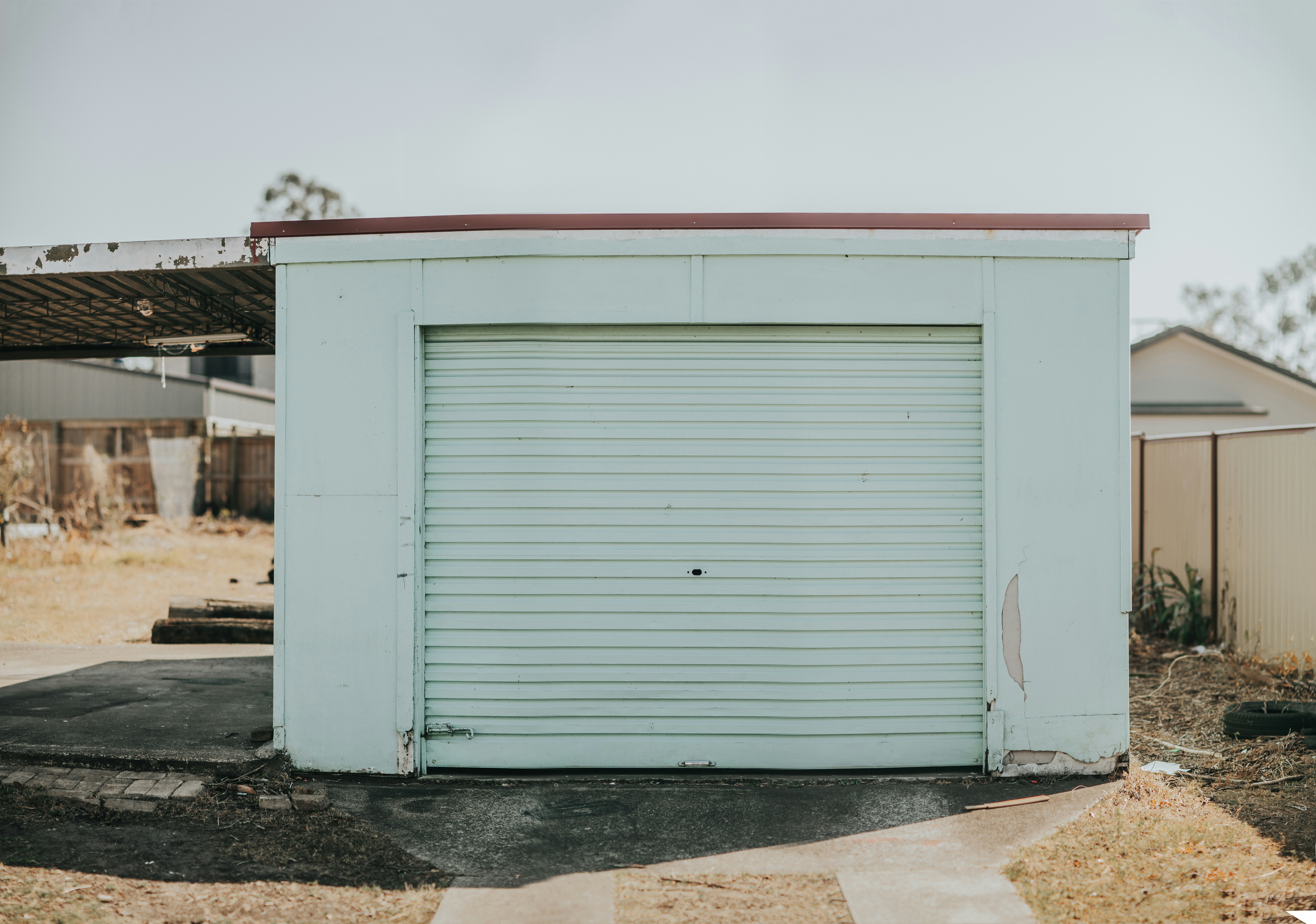 A well-organized modern garage with labeled transparent bins on sturdy metal shelving and a clear floor space.