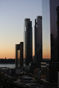 five curtain-wall buildings overlapping other buildings during golden hour photo