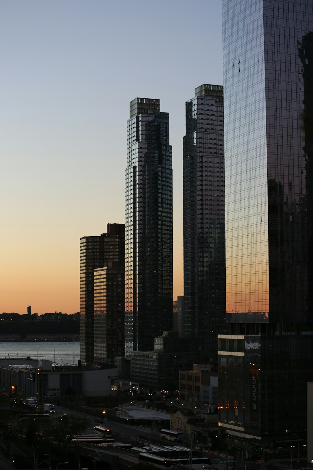 five curtain-wall buildings overlapping other buildings during golden hour photo