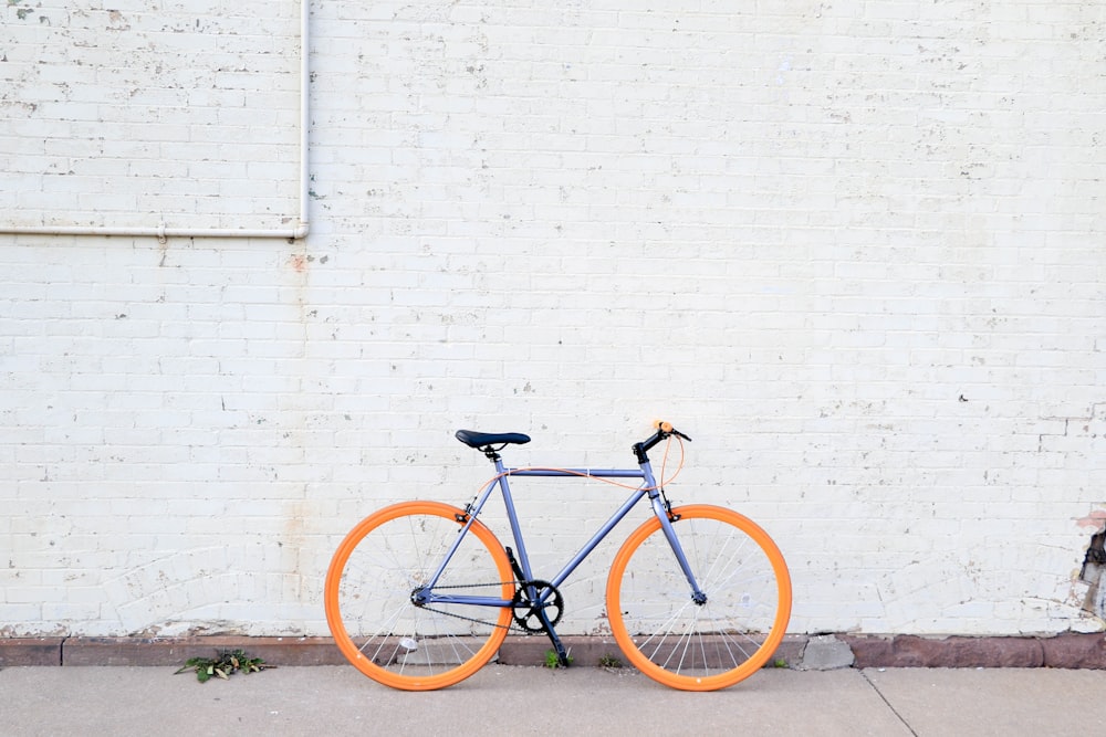 Gelbes und lilafarbenes Fahrrad in der Nähe der weißen Wand am Tag