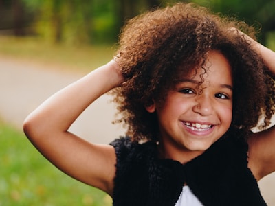 A proud child showing off their new haircut to a smiling parent outside Family Barber.
