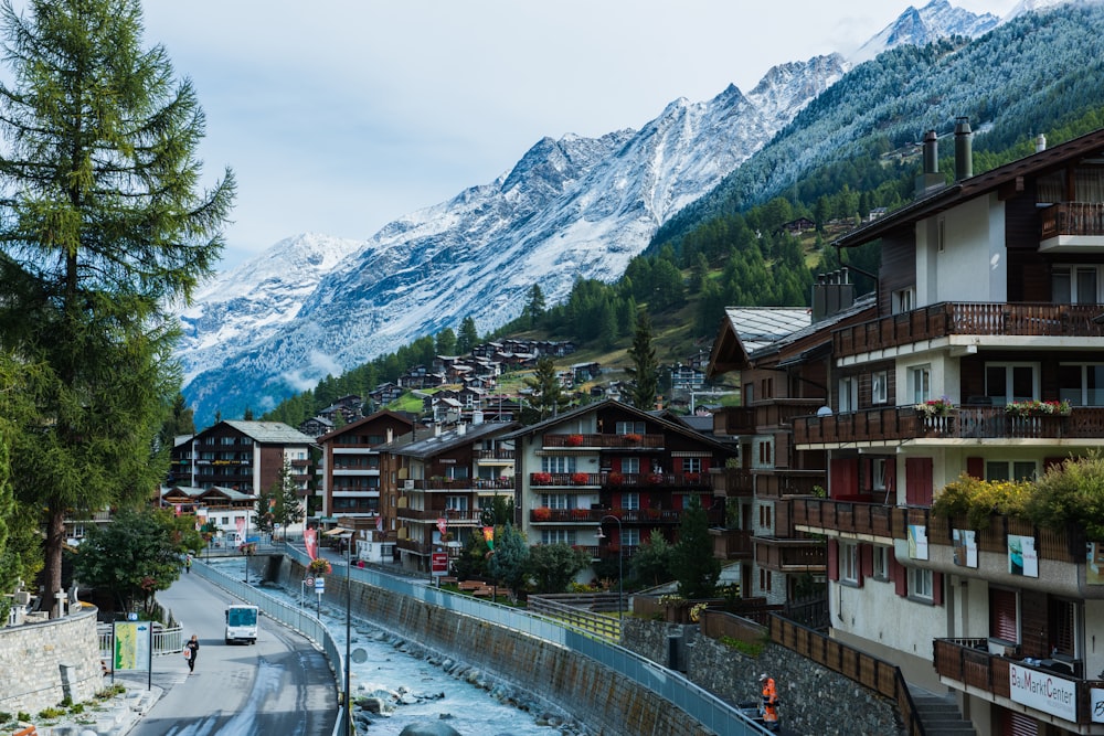 Häuser in der Nähe von Straße und Bergen unter blauem Himmel während der Tagesfotografie