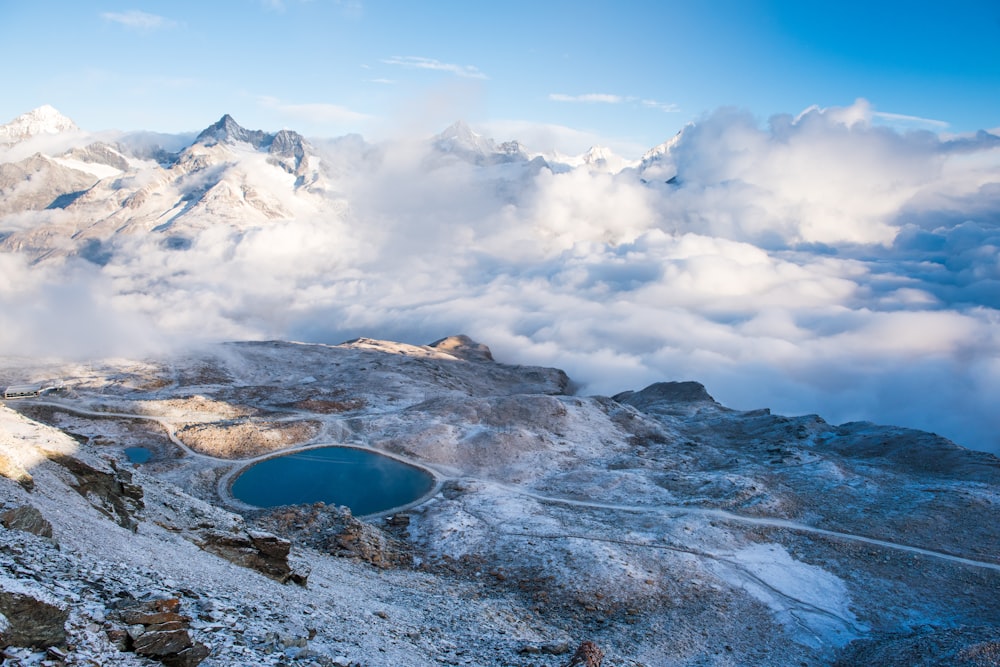 body of water surrounded by mountain under cloudy sky