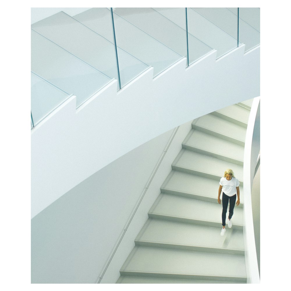 woman wearing white crew-neck t-shirt walking on stairs