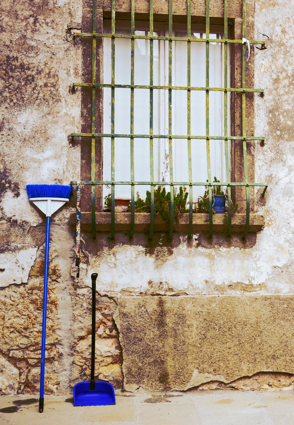 two shovels and a rake in front of a window