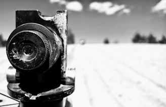 Close-up of a camera lens capturing a dramatic scene outdoors.