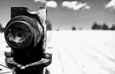 Close-up of a camera lens capturing a dramatic scene outdoors.